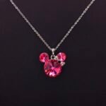 Wholesale fashion cute Mickey necklace with bow featuring Swarovski elements and copper and gold plating from junejewelry.com. Cute cartoon character jewelry for resale.