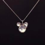 Wholesale fashion cute Mickey necklace with bow featuring Swarovski elements and copper and gold plating from junejewelry.com. Cute cartoon character jewelry for resale.