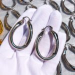 Wholesale Wave Chain Hoop Earrings featuring oversized wave motif and hollow chain buckle on 18K gold- or platinum-plated copper hoops from junejewelry.com—factory price, free shipping.