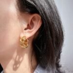 Wholesale C-Shape Hollow Chain Hoop Earrings featuring a geometric C-shape and hollow chain link buckle, plated in 18K gold or platinum copper from junejewelry.com—factory price, free shipping.