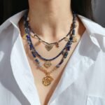 Wholesale lapis lazuli layering necklace featuring lapis beads, a gold coin pendant, shell accents, and 18K gold plated copper from junejewelry.com
