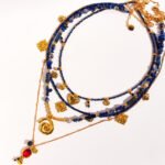 Wholesale lapis lazuli layering necklace featuring lapis beads, a gold coin pendant, shell accents, and 18K gold plated copper from junejewelry.com