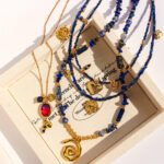 Wholesale lapis lazuli layering necklace featuring lapis beads, a gold coin pendant, shell accents, and 18K gold plated copper from junejewelry.com