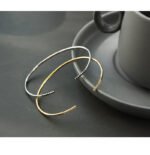 Wholesale cubic zirconia cuff bracelet featuring a minimalist design and 14K gold plated copper from junejewelry.com