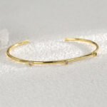 Wholesale CZ cuff bracelet featuring a minimalist design and 14K gold plated copper from junejewelry.com