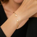 Wholesale European-style opal cuff bracelet featuring a minimalist design with a water drop shaped synthetic opal and 14K gold plated copper from junejewelry.com