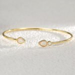 Wholesale European-style opal cuff bracelet featuring a minimalist design with a water drop shaped synthetic opal and 14K gold plated copper from junejewelry.com