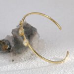 Wholesale European-style opal cuff bracelet featuring a minimalist design with a hexagonal synthetic opal and 14K gold plated copper from junejewelry.com