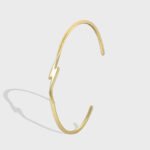 Wholesale lightning cuff bracelet featuring a minimalist lightning bolt design and 14K gold plated copper from junejewelry.com