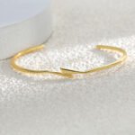 Wholesale lightning cuff bracelet featuring a minimalist lightning bolt design and 14K gold plated copper from junejewelry.com
