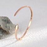 Wholesale European-style snake cuff bracelet featuring an asymmetrical snake design and 14K gold plated copper from junejewelry.com
