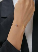 Wholesale European-style minimalist moon cuff bracelet featuring a 14k gold plated copper design with a purple stone from junejewelry.com