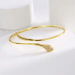 Wholesale European-style minimalist snake cuff bracelet featuring a 14k gold plated copper design with CZ stone detailing from junejewelry.com