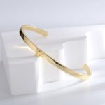 Wholesale European-style minimalist butterfly cuff bracelet featuring a 14k gold plated copper design from junejewelry.com