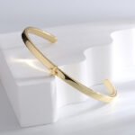 Wholesale European-style minimalist cross cuff bracelet featuring a 14k gold plated copper design from junejewelry.com