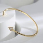 Wholesale Zircon Triangle Open Cuff Bracelet featuring a geometric triangle design with zircon stones on 14K gold-plated copper from junejewelry.com—factory price, free shipping.