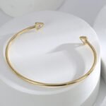 Wholesale Zircon Triangle Open Cuff Bracelet featuring a geometric triangle design with zircon stones on 14K gold-plated copper from junejewelry.com—factory price, free shipping.