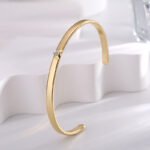 Wholesale Zircon Heart Cuff Bracelet featuring a micro‑pavé zircon heart on a 14K gold‑plated copper open cuff from junejewelry.com—factory price, free shipping.