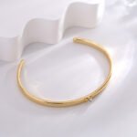 Wholesale Zircon Heart Cuff Bracelet featuring a micro‑pavé zircon heart on a 14K gold‑plated copper open cuff from junejewelry.com—factory price, free shipping.