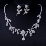 Elegant floral cubic zirconia necklace and earring set with platinum plating on a black background.