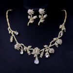 Elegant floral cubic zirconia necklace and earring set with platinum plating on a black background.