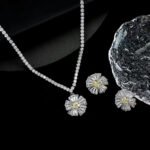Radiant sunburst cubic zirconia necklace and earring set with platinum plating on a black background.