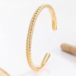 Wholesale European-style minimalist twisted cuff bracelet featuring a 14k gold plated copper design from junejewelry.com