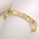 Four Leaf Clover Cuff Bracelet featuring a hollow shamrock motif with micro‑pavé zircon stones on 14K gold‑plated copper from junejewelry.com—factory price, free shipping.