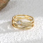 Wholesale Multi-line Ring with multi-line design, zircon inlay, and 18K gold-plated copper – sizes 7 and 8 available at junejewelry.com.