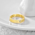Wholesale single stone ring featuring minimalist zircon detail on a glossy 18K gold-plated brass band in sizes 6 to 9 from junejewelry.com.