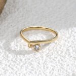 Wholesale dainty zircon ring with single cubic zirconia and 18K gold-plated copper band – stackable minimalist style from junejewelry.com.