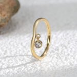 Wholesale dainty zircon ring with single cubic zirconia and 18K gold-plated copper band – stackable minimalist style from junejewelry.com.