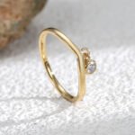 Wholesale dainty zircon ring with single cubic zirconia and 18K gold-plated copper band – stackable minimalist style from junejewelry.com.