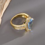 Wholesale French modern minimalist teardrop blue zircon ring for women, 18K gold plated copper with a sparkling blue zircon from junejewelry.com