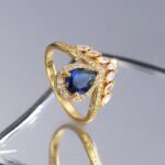 Wholesale teardrop blue ring, 18K gold plated copper, with a teardrop blue zircon and micro-pave white zircons, ideal for fashion jewelry wholesale from junejewelry.com.