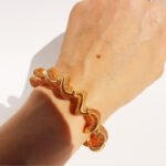 Wholesale spiral cuff bracelet with twisted wave coil design in 18K gold plated brass – Y2K fashion accessory from JuneJewelry.com.