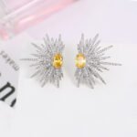 Wholesale starburst stud earrings with a central oval cubic zirconia and micro-pavé stones, platinum-plated brass and 925 silver needle from JuneJewelry.com.