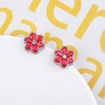 Wholesale Colorful Flower Stud Earrings with a gold plated finish and emerald-colored and clear cubic zirconia stones from JuneJewelry.com – unique fashion jewelry for bulk orders.