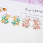 Wholesale Colorful Flower Stud Earrings with a gold plated finish and ruby-colored and clear cubic zirconia stones from JuneJewelry.com – unique fashion jewelry for bulk orders.