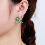 Wholesale Colorful Flower Stud Earrings with a gold plated finish and ruby-colored and clear cubic zirconia stones from JuneJewelry.com – unique fashion jewelry for bulk orders.