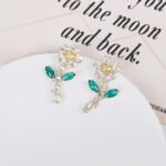 Wholesale Flower Dangle Earrings with a gold plated finish and green and clear cubic zirconia stones from JuneJewelry.com – unique fashion jewelry for bulk orders.