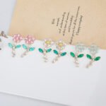 Wholesale Flower Dangle Earrings with a gold plated finish and green and clear cubic zirconia stones from JuneJewelry.com – unique fashion jewelry for bulk orders.