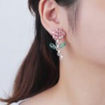 Wholesale Flower Dangle Earrings with a gold plated finish and green and clear cubic zirconia stones from JuneJewelry.com – unique fashion jewelry for bulk orders.