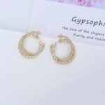 Wholesale gold twisted hoop earrings with baguette and pavé CZ stones from junejewelry.com – unique fashion jewelry for bulk orders.