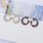 Wholesale gold twisted hoop earrings with baguette and pavé CZ stones from junejewelry.com – unique fashion jewelry for bulk orders.