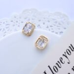 Wholesale vintage gold earrings with an emerald cut CZ stone and a detailed ornate frame from junejewelry.com – classic fashion jewelry for bulk orders.