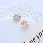 Wholesale Gold Plated Stud Earrings with a cushion-cut cubic zirconia stone on an ornate gold plated brass base from JuneJewelry.com – elegant fashion jewelry for bulk orders.