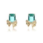 Wholesale starburst stud earrings with a central oval CZ and pavé stones on a platinum-plated brass base from junejewelry.com – unique fashion jewelry for bulk orders.