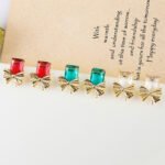 Wholesale starburst stud earrings with a central oval CZ and pavé stones on a platinum-plated brass base from junejewelry.com – unique fashion jewelry for bulk orders.