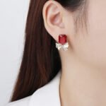 Wholesale starburst stud earrings with a central oval CZ and pavé stones on a platinum-plated brass base from junejewelry.com – unique fashion jewelry for bulk orders.